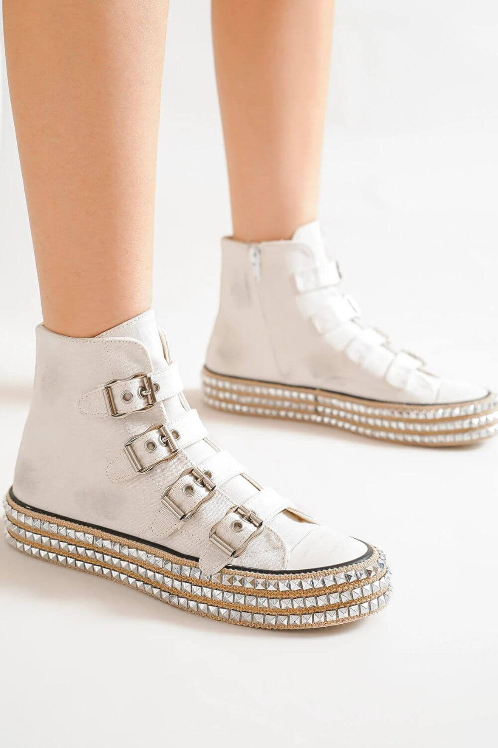 Stylish white multi-buckle platform sneakers with studded details, perfect for edgy fashion lovers.