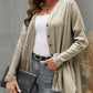 Woman wearing FAM-FAM Ruffled Button Up Long Sleeve Cardigan in khaki with jeans, holding a black clutch.