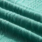 Close-up of mint green textured fabric showing intricate patterns and slight stretch. Made from 97% polyester and 3% elastane.