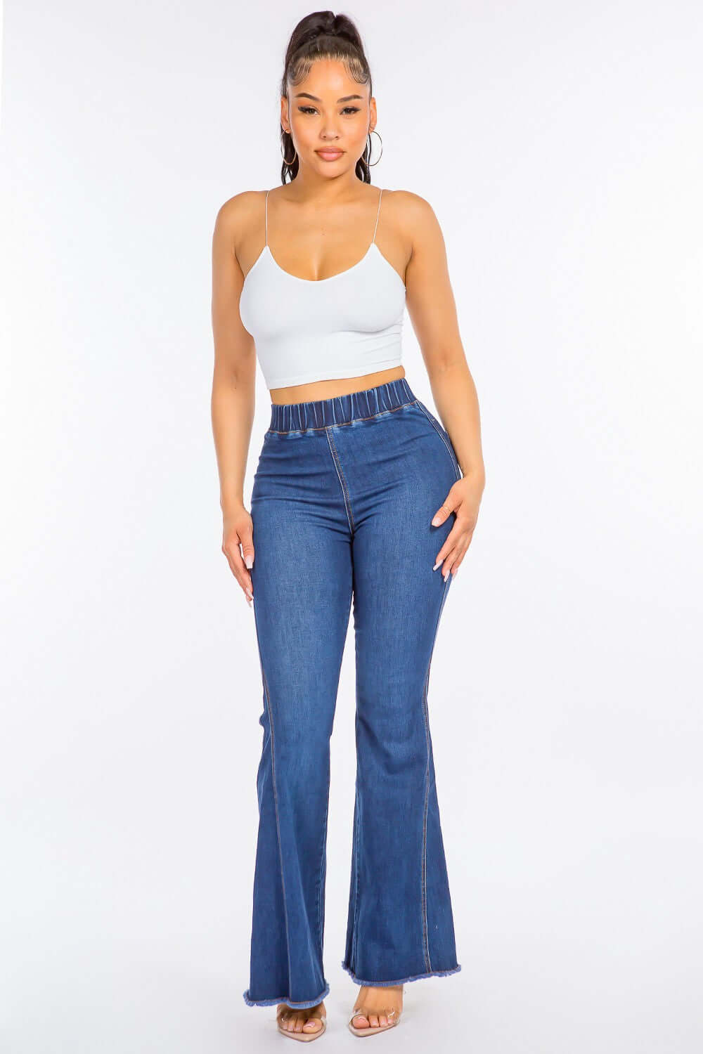 Woman wearing high waist curvy flare jeans with an elastic banded waist and flare bottom. Stylish and trendy jeans for accentuating curves.