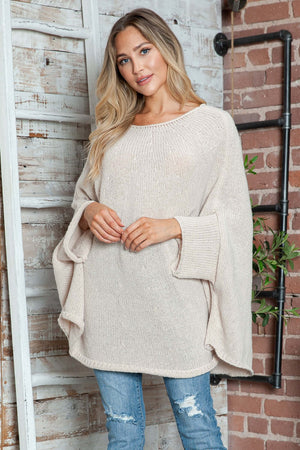 Woman wearing Bella Road Round Neck Batwing Sleeve Sweater in a cozy setting.