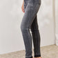 Woman wearing high waist tummy control release hem skinny Judy Blue Jeans, showcasing side view with black color and premium stretch fabric.