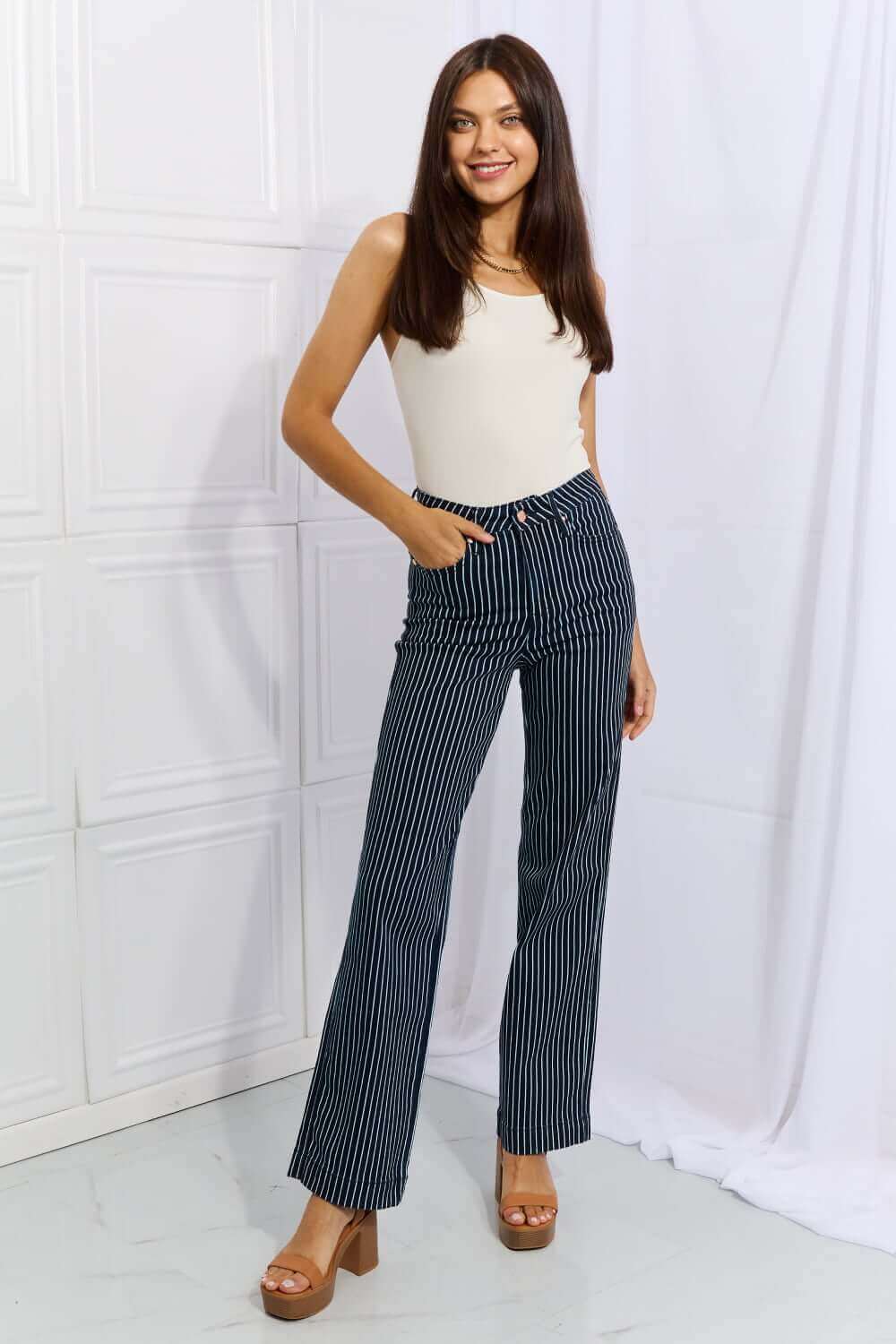 Woman wearing Cassidy Full Size High Waisted Tummy Control Striped Straight Jeans by Judy Blue Jeans.