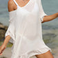 Woman wearing a white tied ruffled half sleeve cover-up at the beach with sheer fabric and relaxed fit.