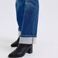 Stylish close-up of mid-rise bootcut jeans with cuffed hems paired with chic black heeled boots. Perfect for any outfit!