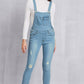 Woman wearing distressed washed denim overalls with pockets, mid waist, slightly stretchy, made of 65% cotton and 35% polyester.