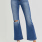 Distressed high-rise crop flare jeans with a trendy ripped knee, worn with white sneakers for a chic, effortless look.