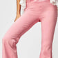 Woman wearing pink Asymmetric Waist Flare Jeans with a white ruffled top, showcasing unique waistline design.