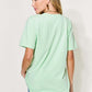 Woman wearing MAMA Round Neck Short Sleeve T-Shirt in light green color, showing back view.