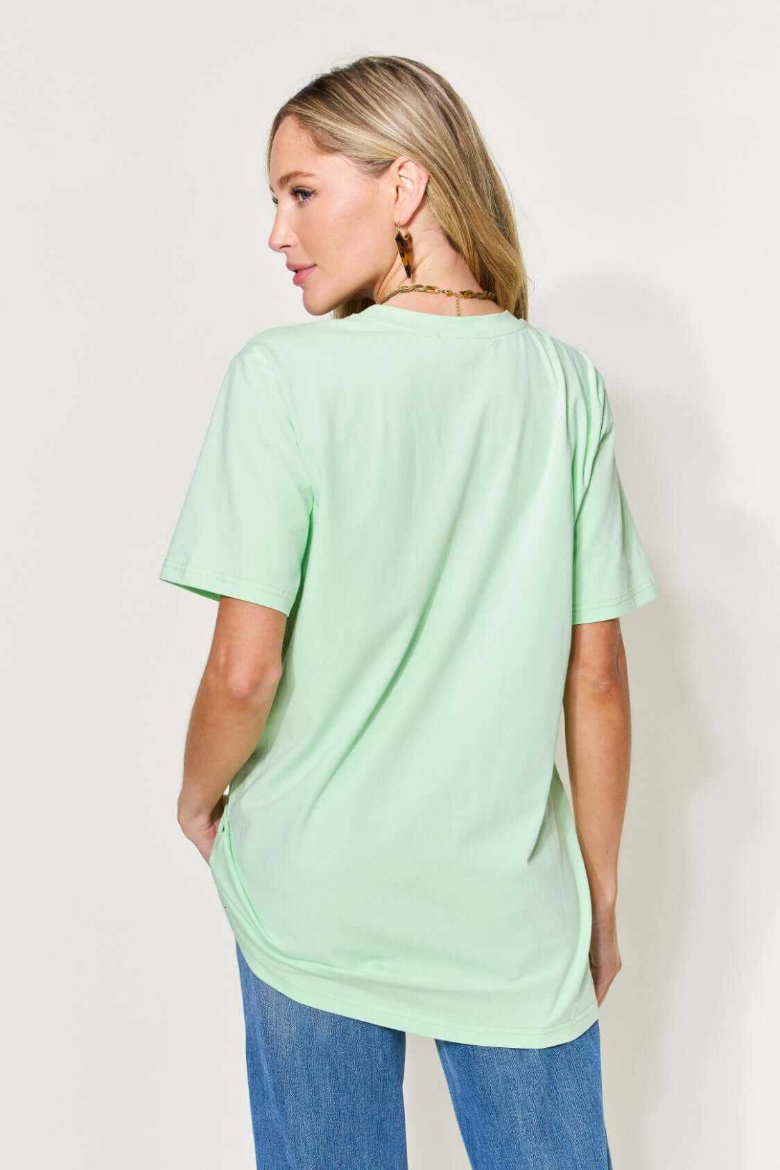 Woman wearing MAMA Round Neck Short Sleeve T-Shirt in light green color, showing back view.