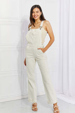 Woman wearing Taylor High Waist Overalls by Judy Blue Jeans, featuring a solid pattern with pockets, perfect for casual outings and adventures