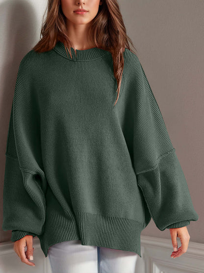 Woman wearing green Double Take Side Slit Round Neck Long Sleeve Sweater with moderate stretch and playful side slit design.