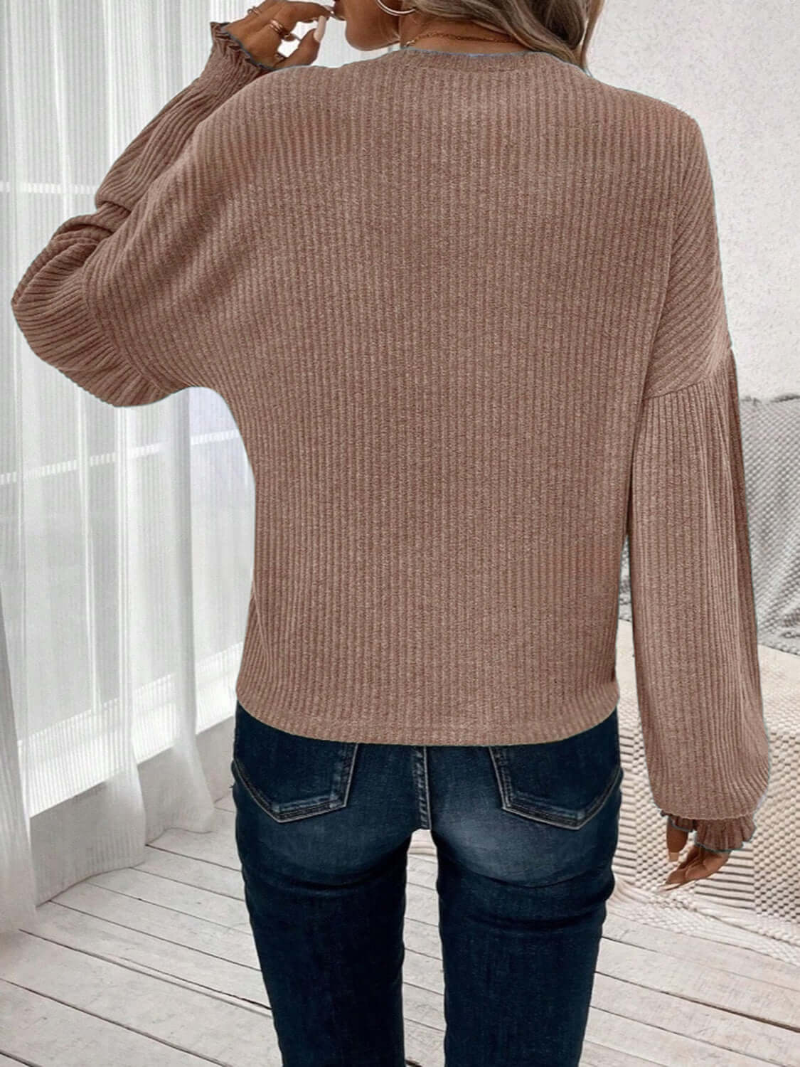 Back view of woman wearing Bella Road Ribbed Round Neck Lantern Sleeve T-Shirt in beige with ribbed texture and lantern sleeves