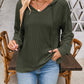 Woman wearing a green drawstring dropped shoulder long sleeve hoodie with jeans.