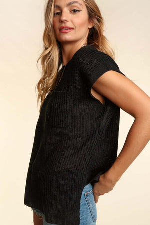 Woman wearing a black pocketed round neck cap sleeve knit top with jeans, showcasing a relaxed and comfortable spring-summer look.