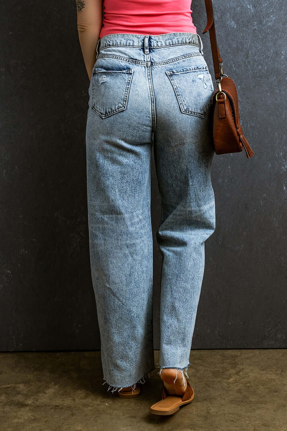 Back view of distressed raw hem straight jeans in petite size, showcasing trendy, playful style with a flattering fit.