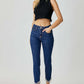 Woman wearing RISEN mid rise crop skinny jeans with embellishments and black sleeveless top