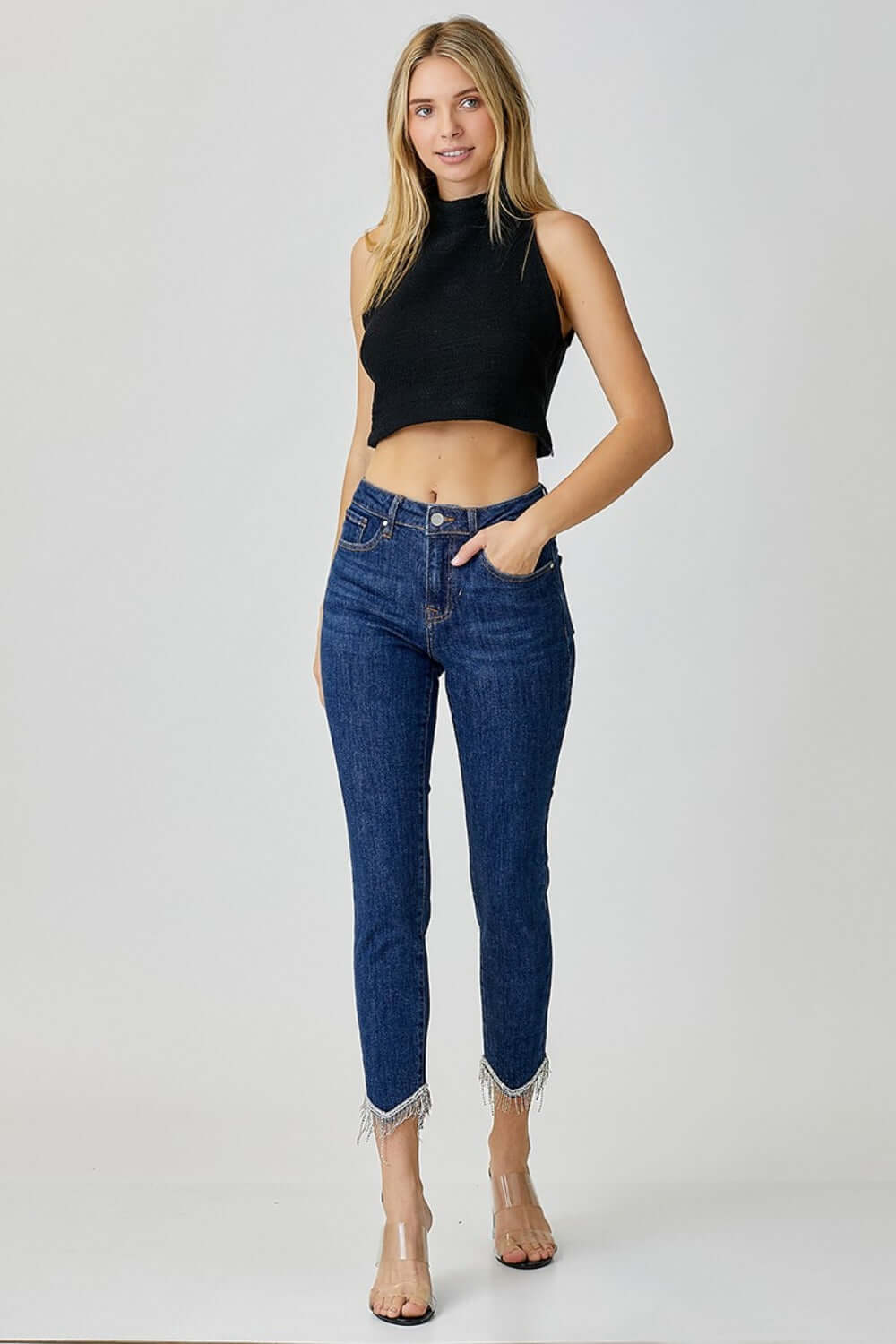 Woman wearing RISEN mid rise crop skinny jeans with embellishments and black sleeveless top