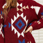 Model wearing a HEYSON Aztec fuzzy sweater with vibrant red, blue, and white geometric patterns, showcasing its cozy texture.