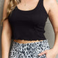 Woman wearing Bow Down sleeveless ruffle crop top in black with square neckline and leopard print pants