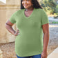 Woman wearing a green Basic Bae Bamboo Full Size V-Neck Short Sleeve T-Shirt outdoors.