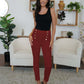 Woman wearing FAM-FAM High Waist Skinny Pants in red with decorative buttons, standing in a stylish room.