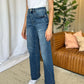 Woman wearing RFM Full Size High Rise Tummy Control Wide Leg Jeans in a relaxed living room setting