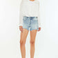 Woman wearing High Rise Side Slit Denim Shorts and white shirt for a stylish summer look