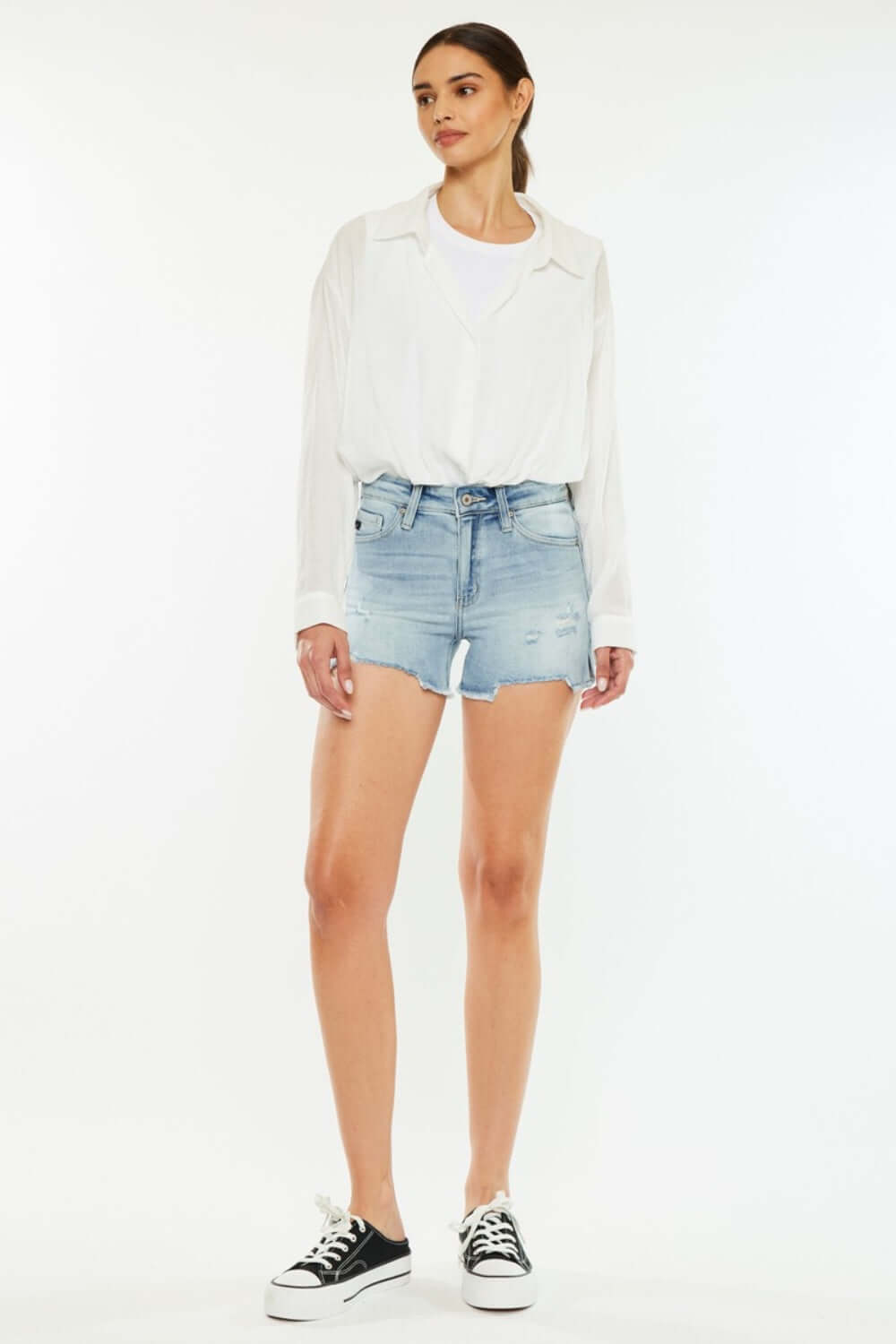 Woman wearing High Rise Side Slit Denim Shorts and white shirt for a stylish summer look