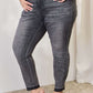 Woman wearing High Waist Tummy Control Release Hem Skinny Jeans in black by Judy Blue Jeans, offering a flattering and comfortable fit.