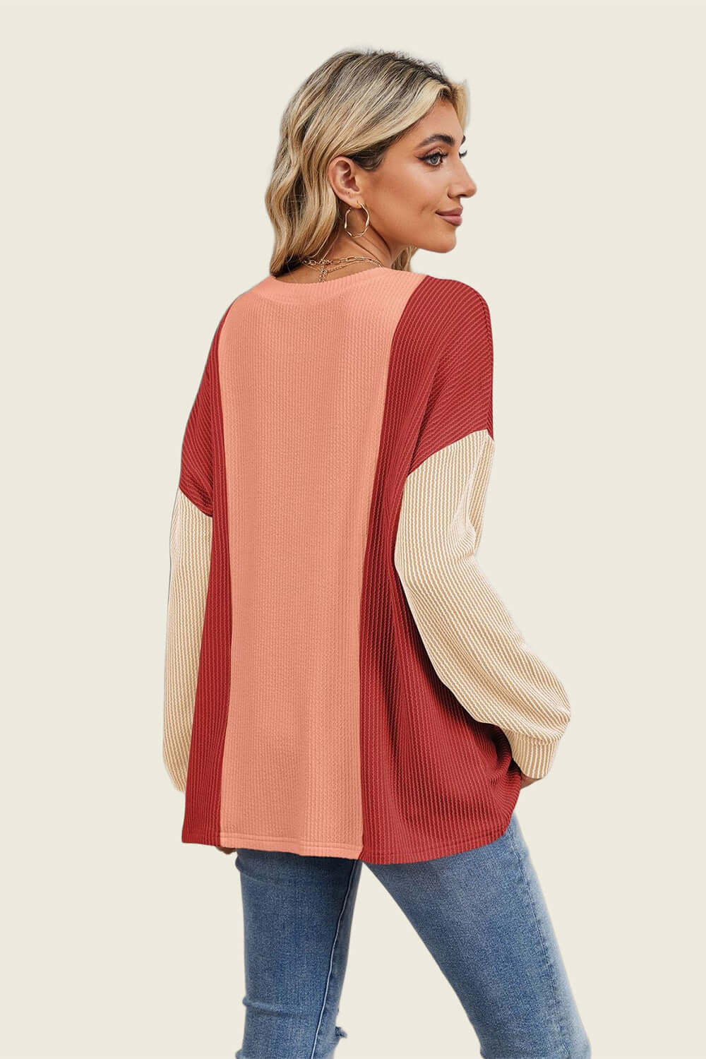 Woman wearing a Double Take Texture Contrast Long Sleeve T-Shirt in red and beige tones, showcasing trendy and stylish layers.