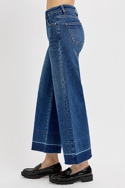 Side view of RISEN tummy control high rise crop wide hem jeans with black platform shoes.