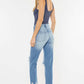 Woman wearing High Waist Chewed Up Straight Mom Jeans in light blue with distressed holes and frayed edges, showcasing a trendy and edgy vintage style.