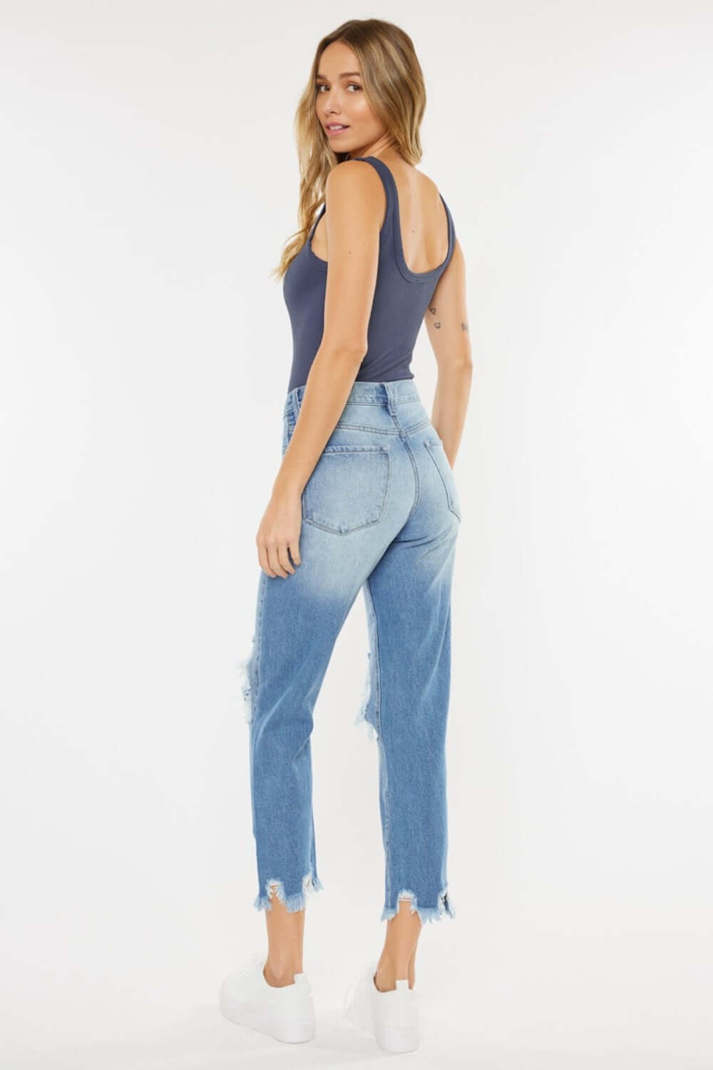 Woman wearing High Waist Chewed Up Straight Mom Jeans in light blue with distressed holes and frayed edges, showcasing a trendy and edgy vintage style.