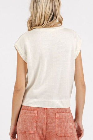 Back view of stylish contrast letter cap sleeve knit top in cream, paired with trendy pants for a casual look.