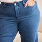 Woman wearing RFM jeans, showcasing Crop Chloe Full Size Tummy Control High Waist Raw Hem design in blue denim.