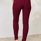 Mid-rise burgundy skinny jeans with stretch from YMI Jeans showcasing back pockets and trendy fit.