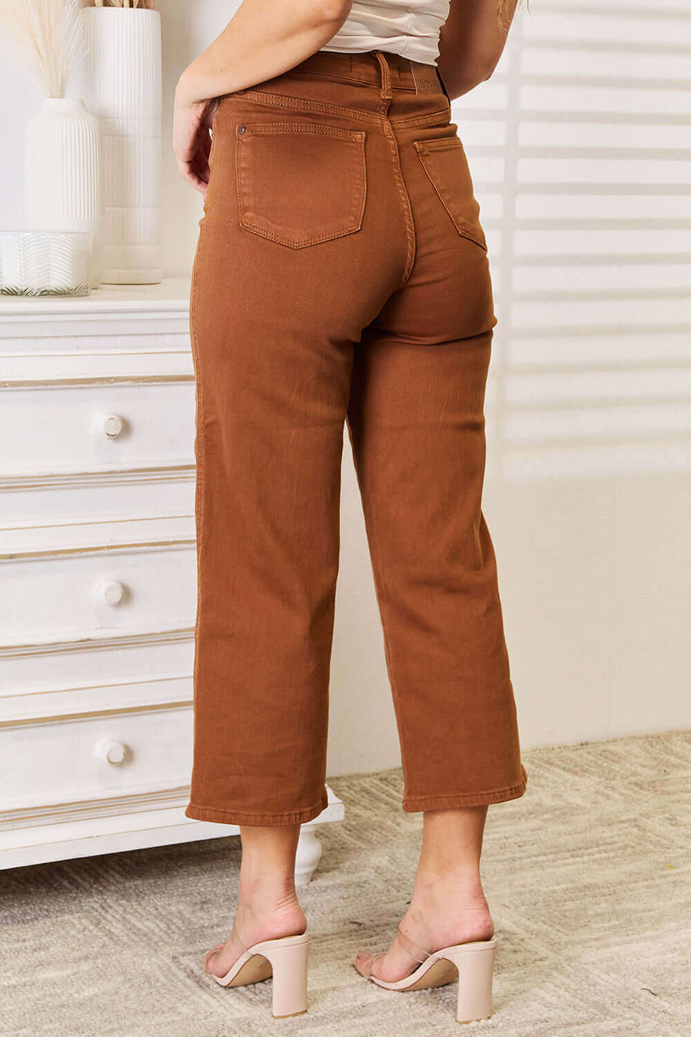 Rear view of model wearing Judy Blue tummy control wide crop jeans in a chic garment-dyed brown color