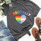 Dark grey round neck short sleeve t-shirt with "Proud Ally" and rainbow heart design, paired with jeans and sandals.