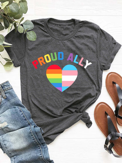 Dark grey round neck short sleeve t-shirt with "Proud Ally" and rainbow heart design, paired with jeans and sandals.