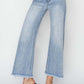 Fashionable high rise crop wide fray hem jeans paired with heels for a chic and edgy style statement.