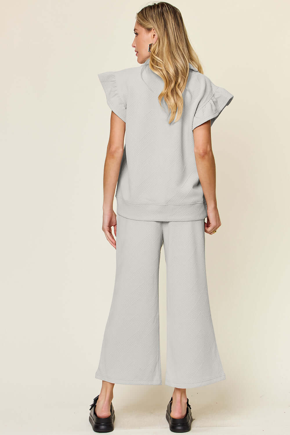 Back view of a grey Texture Ruffle Short Sleeve Top and Drawstring Wide Leg Pants Set worn by a woman.