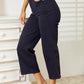 Woman wearing high waist tummy control garment dyed wide cropped Judy Blue Jeans in a stylish setting.