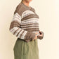 Stylish woman in Davi & Dani crochet drop shoulder cover up with contrasting stripes, paired with relaxed green pants.