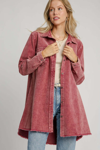 Stylish woman wearing a pink raw hem button down denim jacket with chest pockets over a casual outfit.