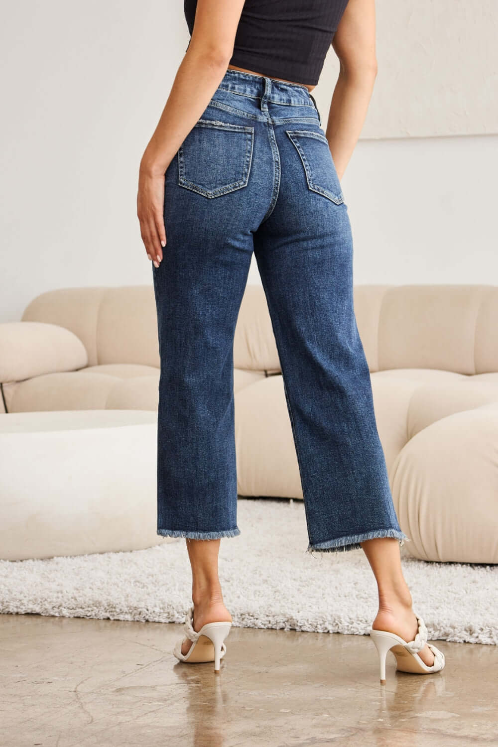 Woman wearing RFM Tummy Control High Waist Raw Hem Jeans, showcasing the back view and raw hem detailing