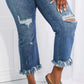 Woman wearing Risen Jeans' distressed undone chic straight leg jeans with raw hem and green sandals