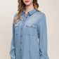 Woman wearing scooped hem button up denim shirt with long sleeves and collar