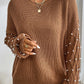 Woman wearing Bella Road Pearl Detail Round Neck Long Sleeve Sweater in brown with elegant pearl accents. Perfect for stylish occasions.