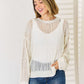 Woman wearing Openwork Ribbed Trim Long Sleeve Knit Top in white with modern openwork design and flattering silhouette.